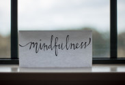 Foto von einem Zettel mit der Aufschrift "mindfulness" und im Hitergrund sieht man ein Fenster