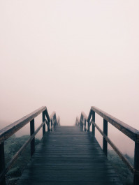 Foto mit einer langen Holztreppe, die im weißen nebel verschwindet
