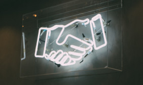 Foto mit lichtern in Form von zwei Händen die sich die Hand geben